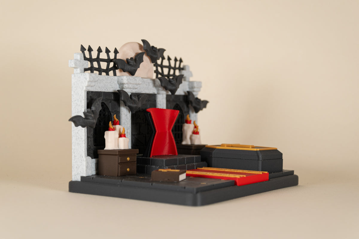 Le Repaire de Dracula MinoZoo en vue trois-quarts gauche, avec trône rouge, cercueil et chauves-souris.