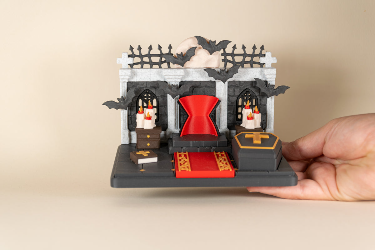 Le Repaire de Dracula MinoZoo tenu dans une main pour montrer les dimensions du décor miniature.