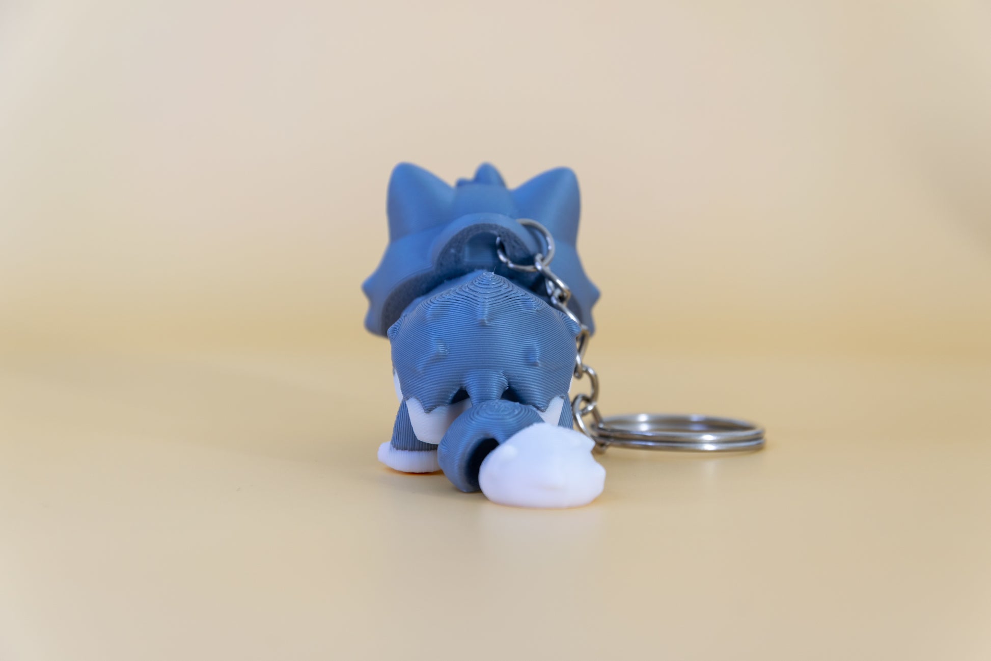 Porte-clés Chat articulé MinoZoo gris doux et crème, vue de dos avec queue segmentée et anneau.
