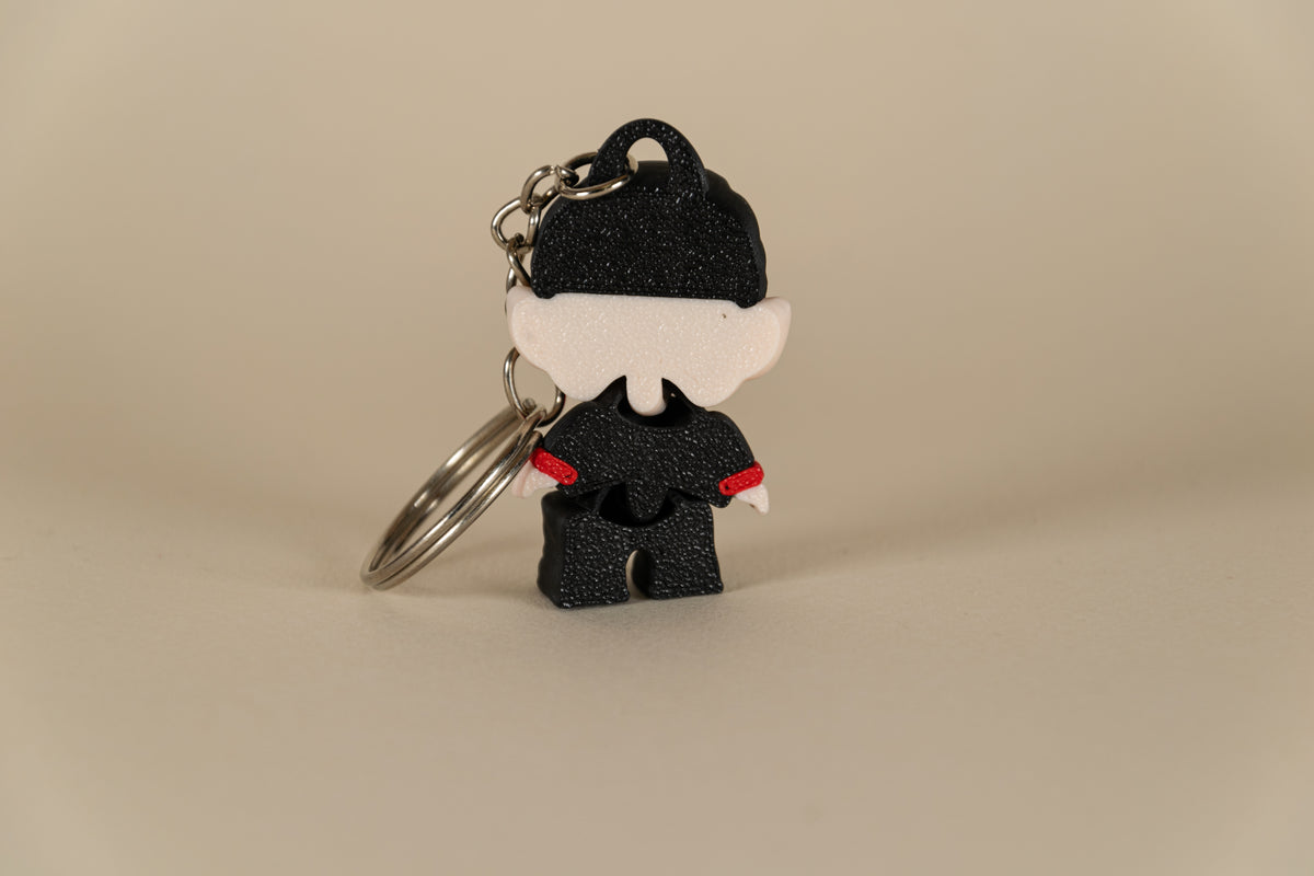 Porte-clés Dracula articulé MinoZoo noir, beige et rouge, vue de dos avec anneau métallique.