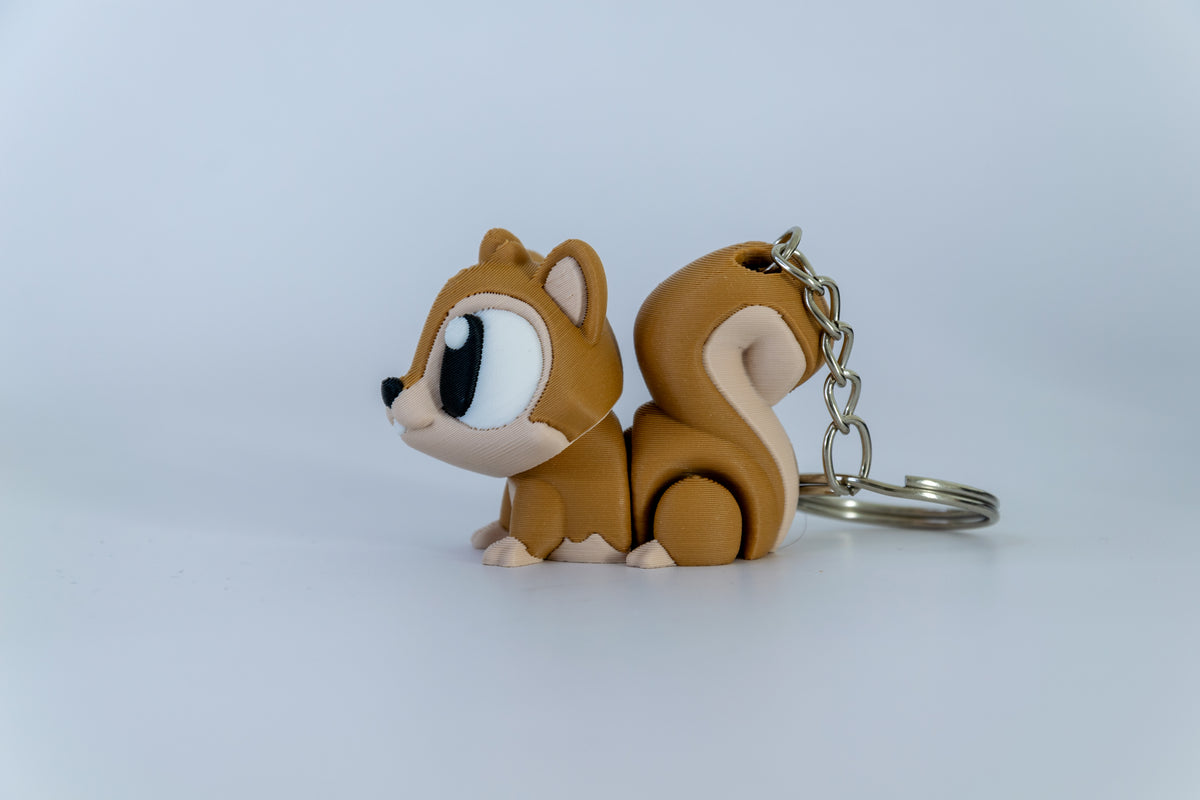 Porte-clés Écureuil articulé MinoZoo brun et brun clair, vue de profil sur fond clair.