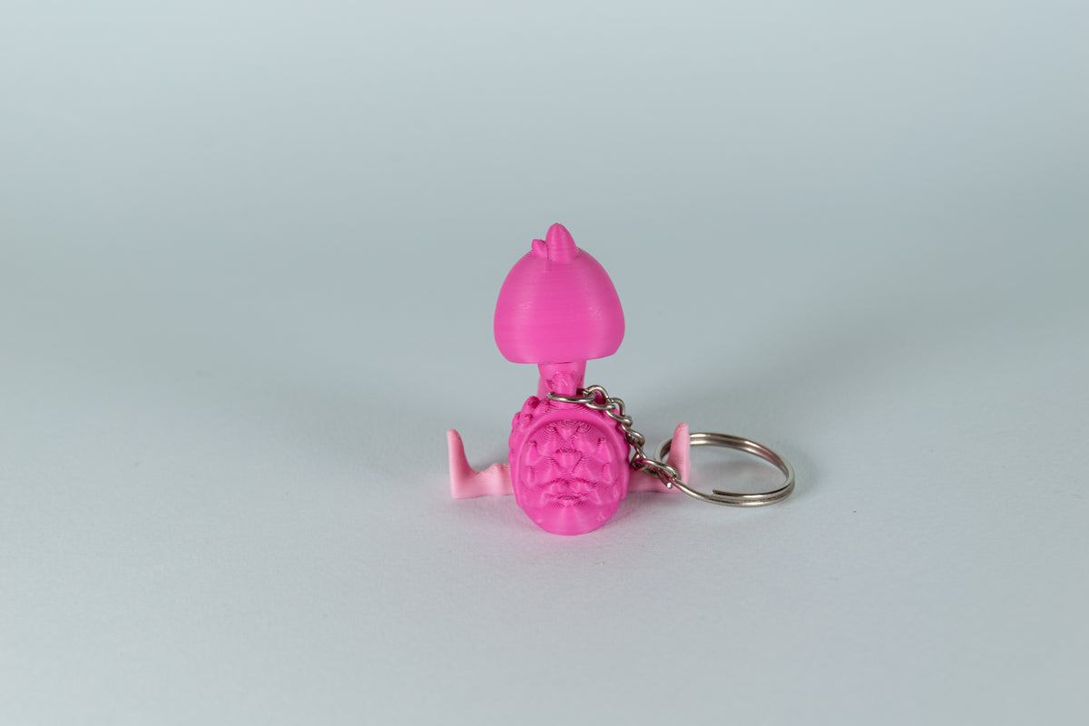 Porte-clés Flamant Rose articulé MinoZoo rose, vue de dos avec pattes écartées et anneau métallique.