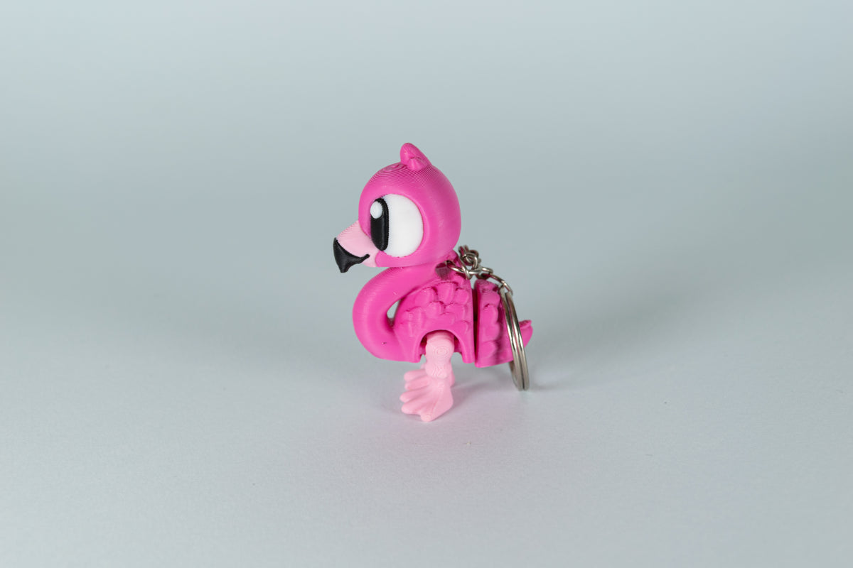 Porte-clés Flamant Rose articulé MinoZoo rose, rose clair et noir, vue de profil avec anneau métallique.