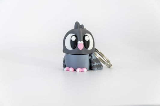 Porte-clés Pigeon articulé MinoZoo gris foncé, gris bleuté et rose, posé de face sur fond blanc.
