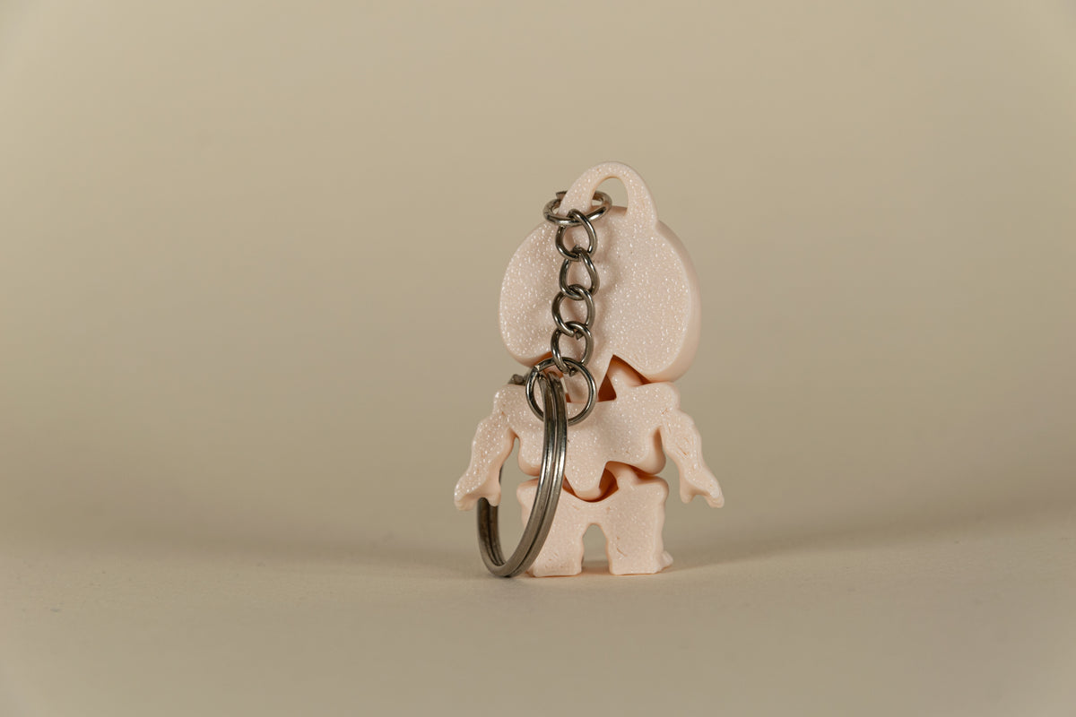 Porte-clés Skeleton articulé MinoZoo beige, vue de dos avec chaîne et anneau métallique.