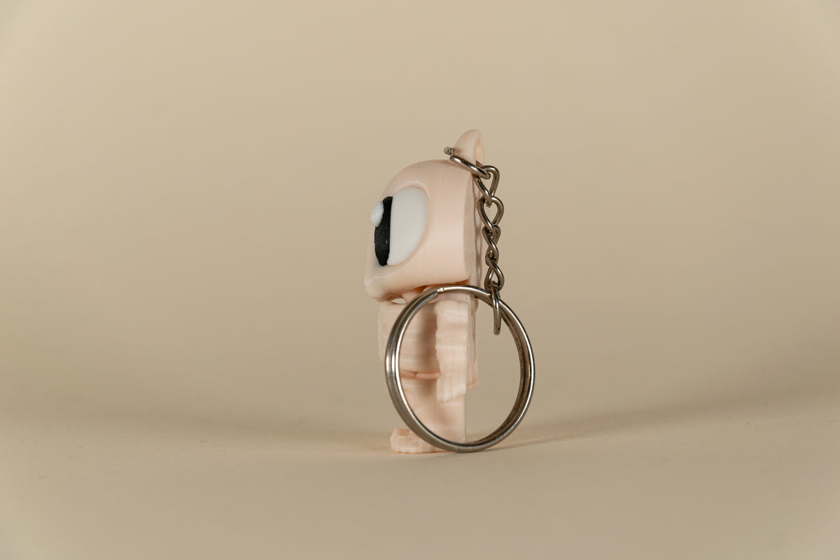 Porte-clés Skeleton articulé MinoZoo beige, vue de profil avec chaîne et anneau métallique.