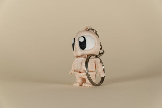 Porte-clés Skeleton articulé MinoZoo beige, noir et blanc, vue trois-quarts avec anneau métallique.